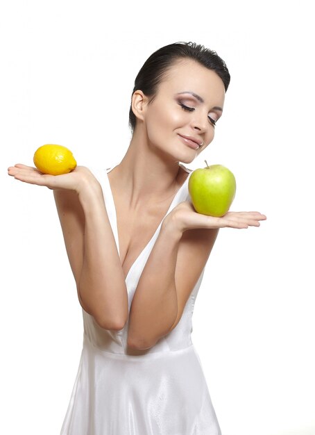 Retrato de hermosa niña sonriente feliz con frutas limón y manzana verde aislado en blanco