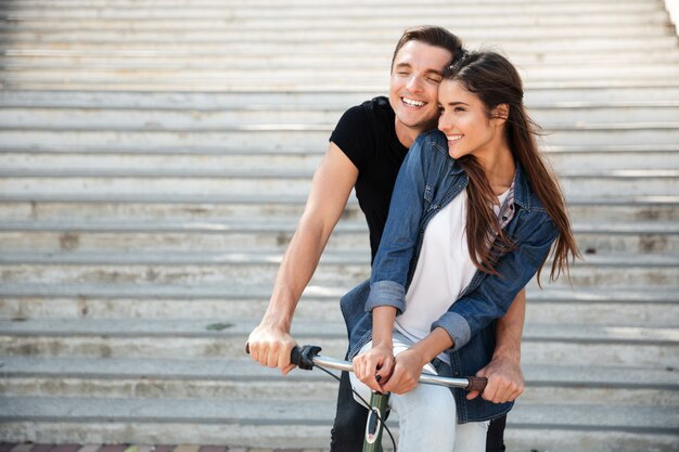 Retrato de una hermosa pareja encantadora montando en bicicleta