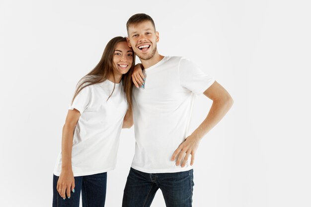 Retrato de hermosa pareja joven aislado sobre fondo blanco de estudio. Expresión facial, emociones humanas, concepto publicitario. Copyspace. Mujer y hombre parados juntos y abrazados, se ven felices.