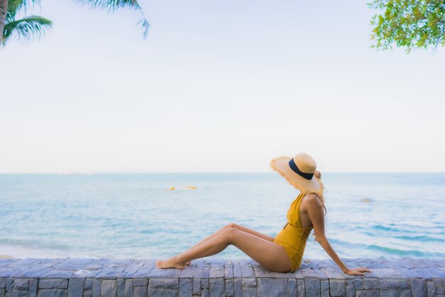 Retrato hermosas mujeres asiáticas jóvenes felices relajarse sonreír alrededor del mar playa océano