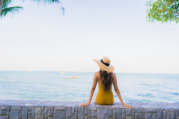 Retrato hermosas mujeres asiáticas jóvenes felices relajarse sonreír alrededor del mar playa océano