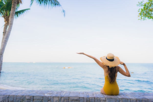 Retrato hermosas mujeres asiáticas jóvenes felices relajarse sonreír alrededor del mar playa océano