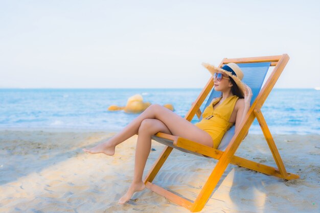 Retrato hermosas mujeres asiáticas jóvenes felices relajarse sonreír alrededor del mar playa océano