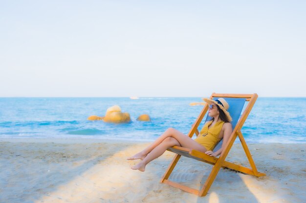 Retrato hermosas mujeres asiáticas jóvenes felices relajarse sonreír alrededor del mar playa océano