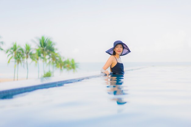 Retrato hermosas mujeres asiáticas jóvenes feliz sonrisa relajarse piscina al aire libre en el hotel