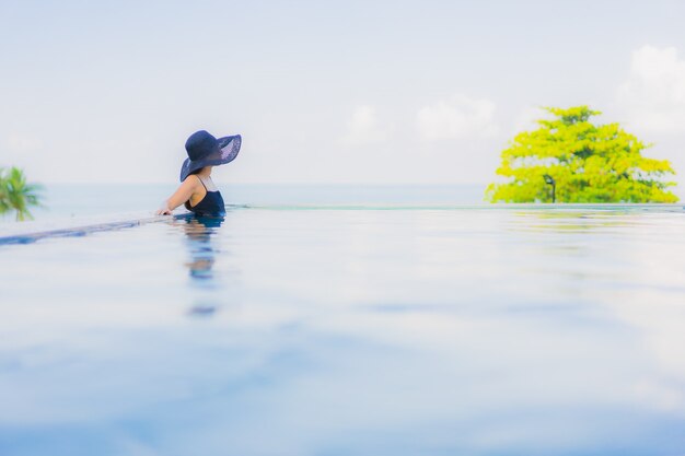 Retrato hermosas mujeres asiáticas jóvenes feliz sonrisa relajarse piscina al aire libre en el hotel