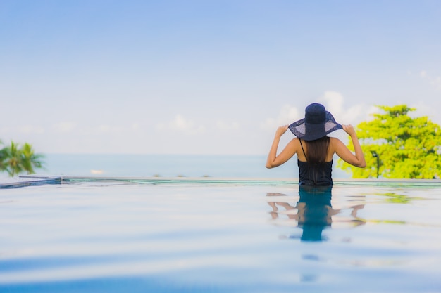 Retrato hermosas mujeres asiáticas jóvenes feliz sonrisa relajarse piscina al aire libre en el hotel