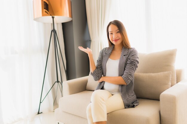 Retrato hermosas mujeres asiáticas jóvenes feliz sonrisa relajarse sentado en el sillón