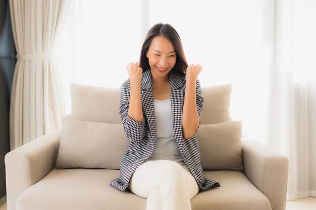 Retrato hermosas mujeres asiáticas jóvenes feliz sonrisa relajarse sentado en el sillón