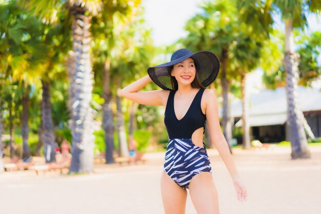 Retrato hermosas mujeres asiáticas jóvenes relajarse sonreír feliz alrededor del mar playa océano