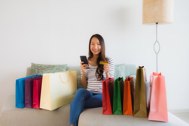 Retrato hermosas mujeres asiáticas jóvenes con teléfono móvil con tarjeta de crédito o computadora para ir de compras