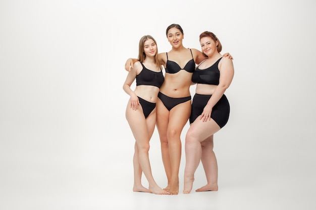 Retrato de hermosas mujeres jóvenes con diferentes formas posando en blanco