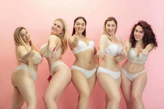 Foto gratuita retrato de hermosas mujeres jóvenes de talla grande posando en rosa