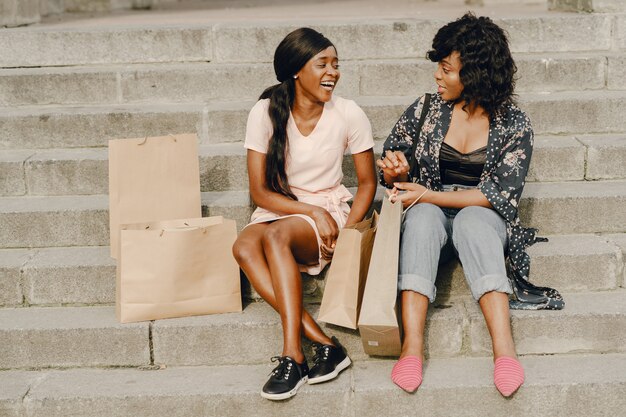 Retrato de hermosas mujeres negras jóvenes con bolsas de la compra.