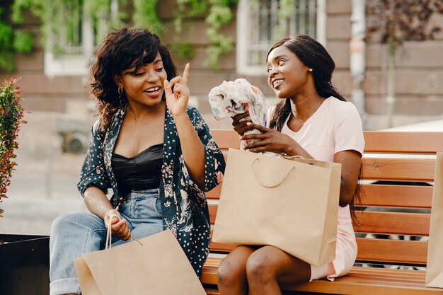 Retrato de hermosas mujeres negras jóvenes con bolsas de la compra.