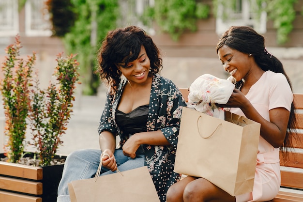 Retrato de hermosas mujeres negras jóvenes con bolsas de la compra.