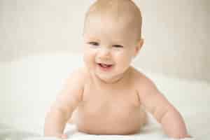 Foto gratuita retrato de un hermoso bebé riendo expresivo, tiene la cabeza hacia arriba