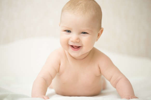 Retrato de un hermoso bebé riendo expresivo, tiene la cabeza hacia arriba