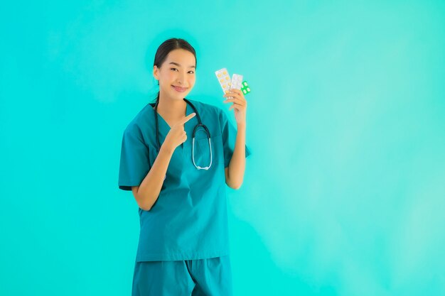 Retrato hermoso joven médico asiático mujer con píldora o drogas y medicamentos