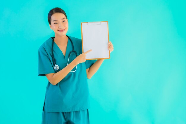 Retrato hermoso joven médico asiático mujer con tablero de papel vacío para espacio de copia