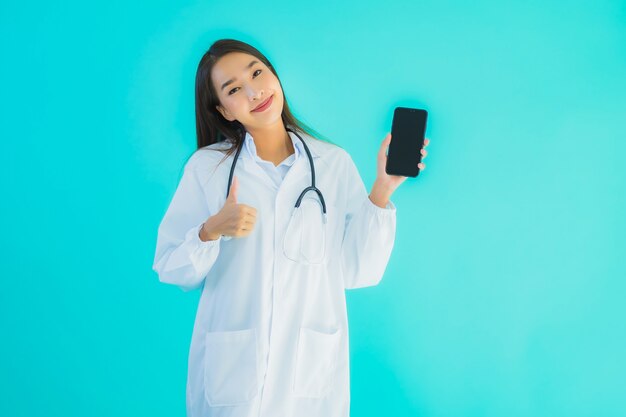 Retrato hermoso joven médico asiático mujer usar teléfono celular inteligente móvil