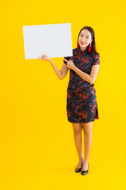 Retrato hermoso joven mujer asiática usar vestido chino mostrar blanco cartelera vacía