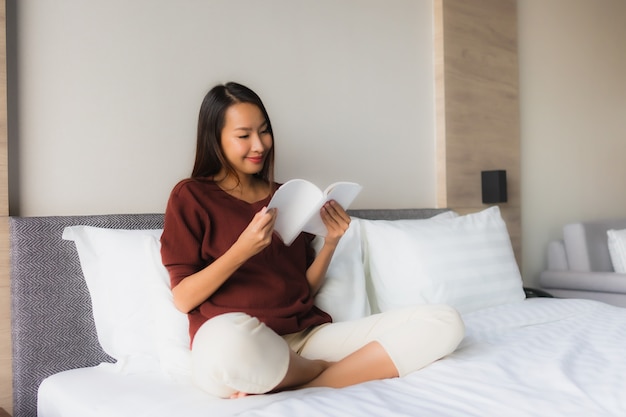 Retrato hermoso libro de lectura de mujeres asiáticas jóvenes en cama