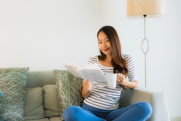 Retrato hermoso libro de lectura de mujeres asiáticas jóvenes con taza de café