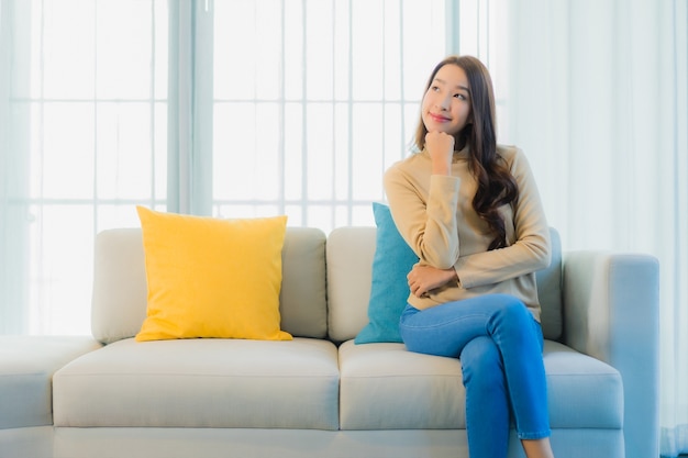 Retrato, de, hermoso, mujer joven, en, sofá, en, sala