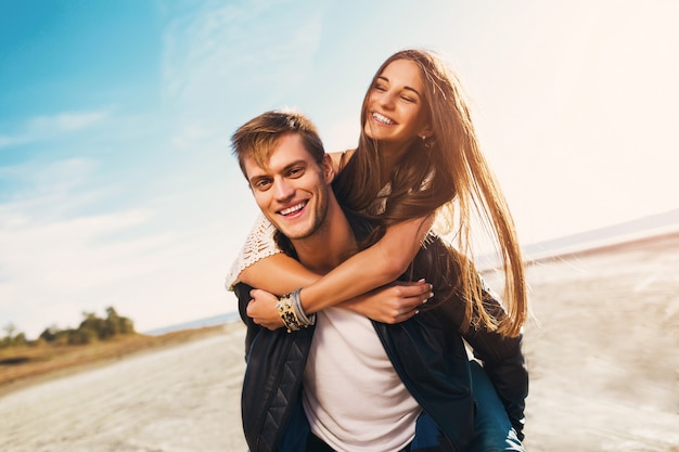 Retrato hermoso sano jóvenes adultos novia y novio abrazando feliz. Joven bonita pareja de enamorados que datan en la primavera soleada a lo largo de la playa. Colores cálidos.