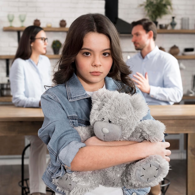 Retrato de hija triste con oso de peluche