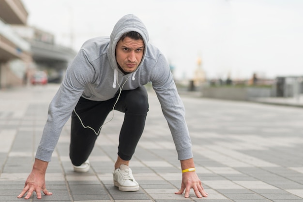 Retrato de hombre adulto preparándose correr