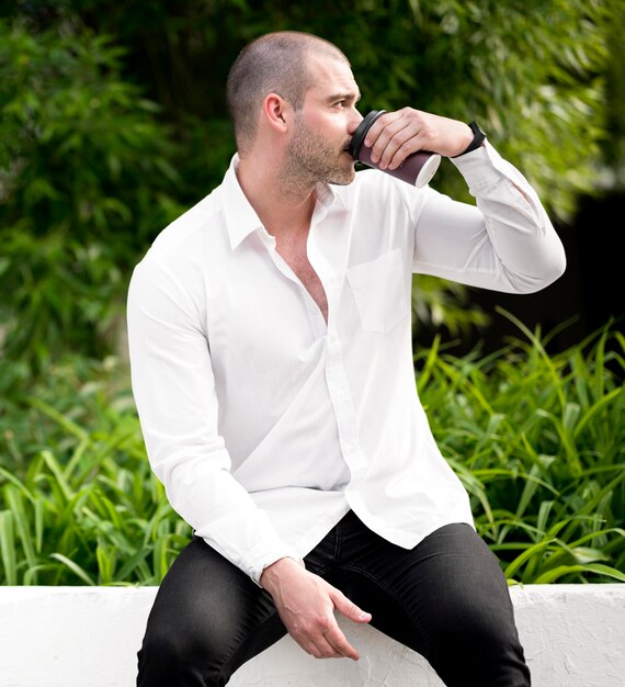 Retrato de hombre adulto tomando café al aire libre