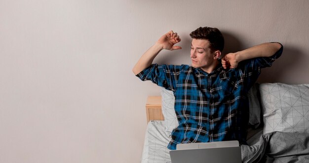 Retrato de hombre adulto trabajando desde la cama