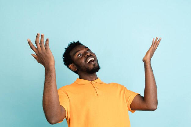 Retrato de hombre africano aislado sobre fondo de estudio azul con copyspace