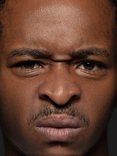 Retrato de hombre afroamericano joven y emocional de cerca. Sesión fotográfica muy detallada de modelo masculino con piel bien cuidada y expresión facial brillante. Concepto de emociones humanas. Indignado.