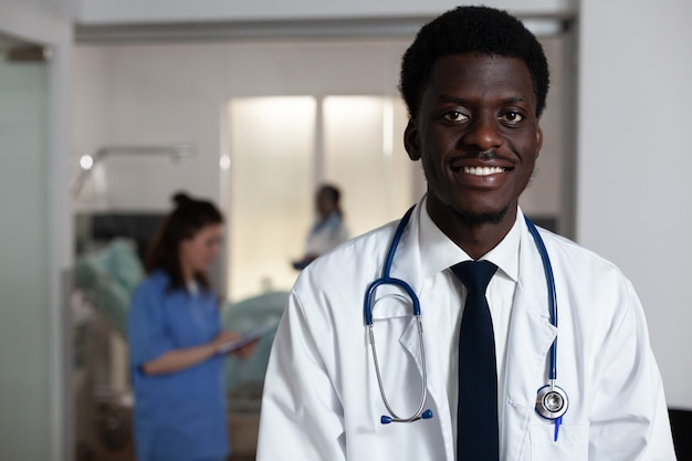Retrato de hombre afroamericano que trabaja en el mostrador de la sala de hospital