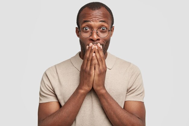 Retrato de hombre afroamericano tiene feliz expresión de sorpresa