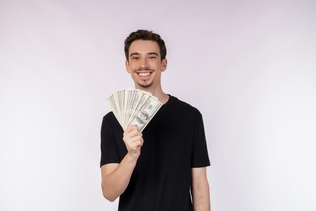 Retrato de un hombre alegre con billetes de dólar sobre fondo blanco.