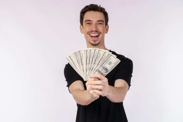 Retrato de un hombre alegre con billetes de dólar sobre fondo blanco.