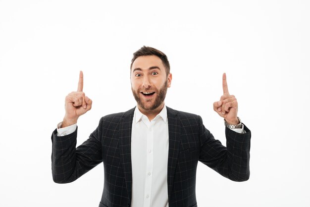 Retrato de un hombre alegre feliz apuntando dos dedos hacia arriba