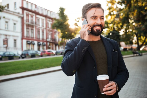 Retrato de un hombre alegre hablando por teléfono móvil