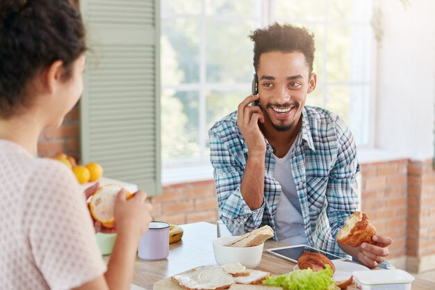 Retrato de hombre alegre que se alegra de escuchar al viejo mejor amigo por teléfono móvil,