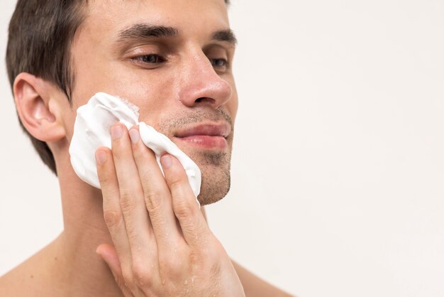 Retrato de un hombre aplicando espuma de afeitar