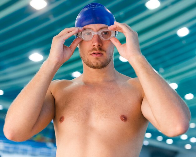 Retrato de hombre arreglando gafas de natación