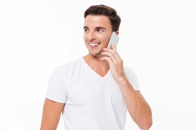 Retrato de un hombre atractivo sonriente en camiseta blanca