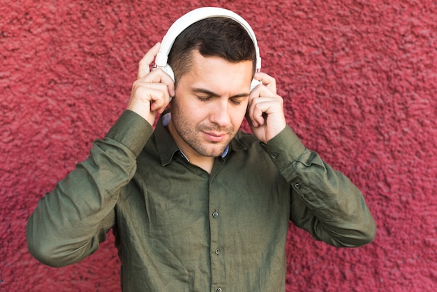 Retrato de hombre con auriculares escuchando música