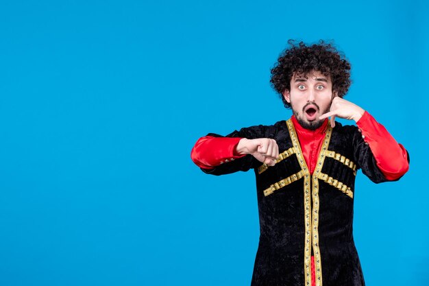 Retrato de hombre azerí en traje tradicional imitando llamada telefónica fondo azul étnico novruz primavera