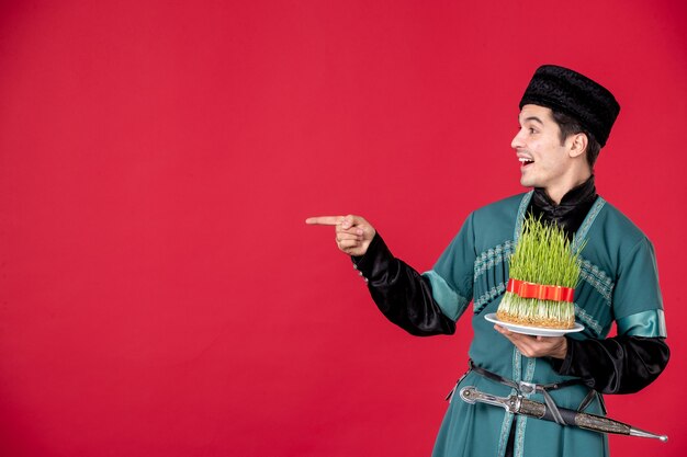 Retrato de hombre azeri en traje tradicional sosteniendo semeni studio shot rojo concepto primavera novruz bailarines