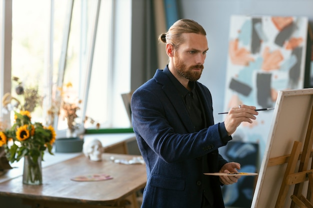 Foto gratuita retrato, de, hombre barbudo, en, un, arte, estudio